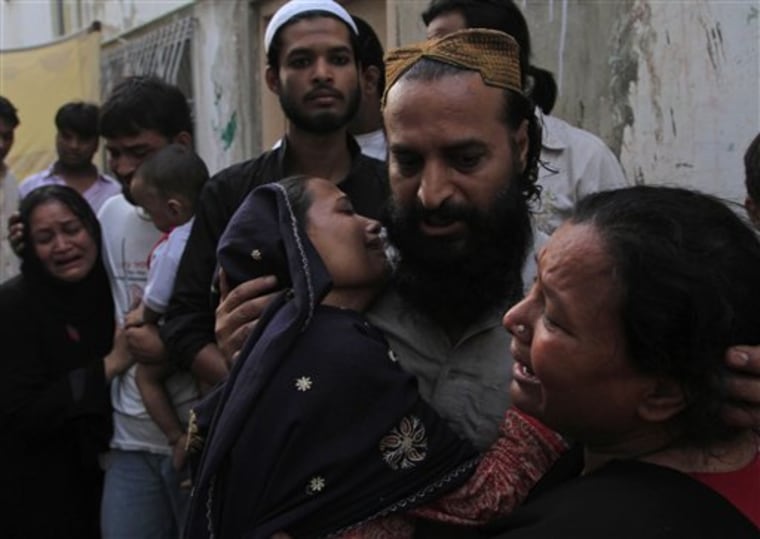 Family members of a target killing victim mourn his death in Karachi, Pakistan on Wednesday, Aug 17, 2011. At least seven people died in the latest violence included a former parliamentarian of ruling party in the port city of Karachi, police said. (AP Photo/Shakil Adil)